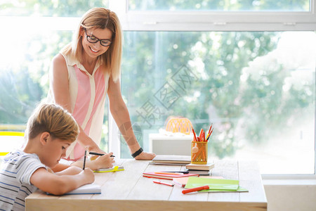 在学校帮助孩子们上课的女老师图片