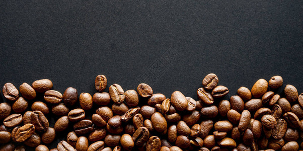深色背景中的烤棕色咖啡豆顶视图背景图片