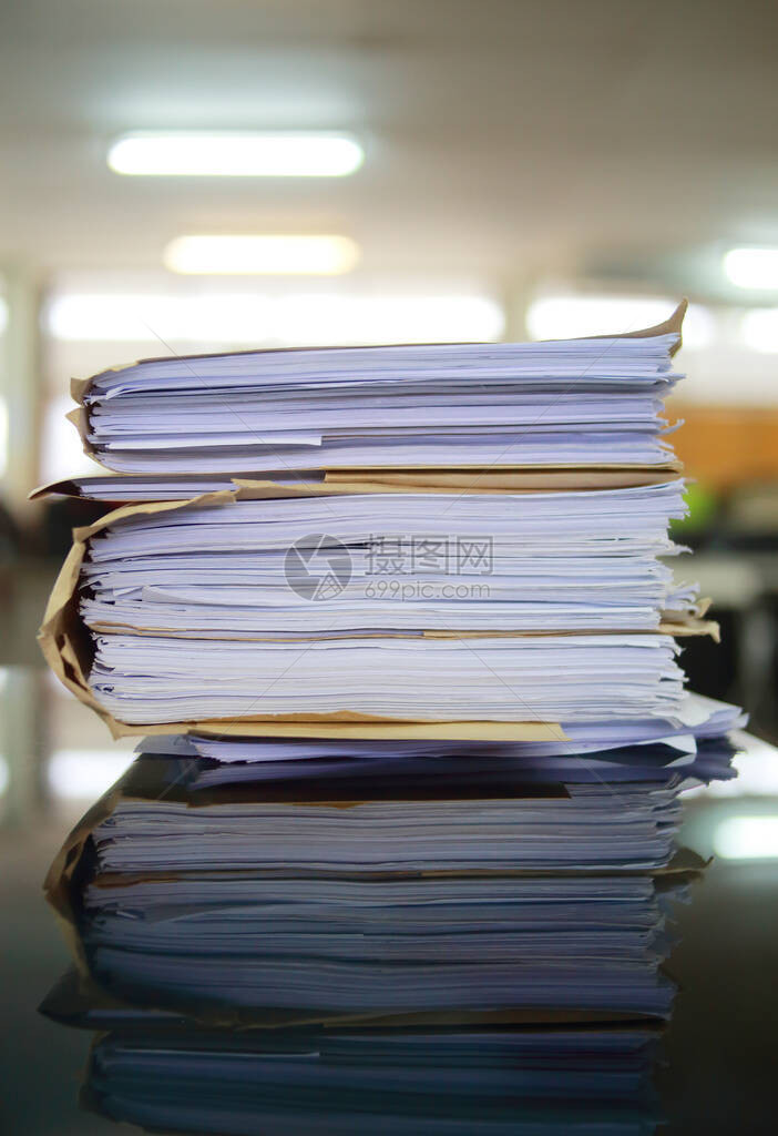 未完成的纸质商业文件堆叠在办公桌档案上图片