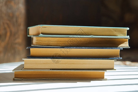 一堆木制背景的书有美丽的阴影浅色图片
