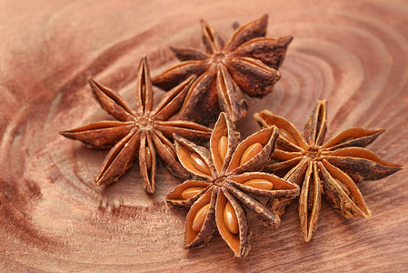 棕色木桌上的茴香星或茴香树料微距拍摄背景图片