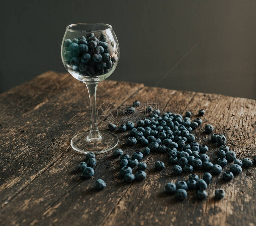 新鲜的蓝色哑光圆形蓝莓装满透明玻璃图片