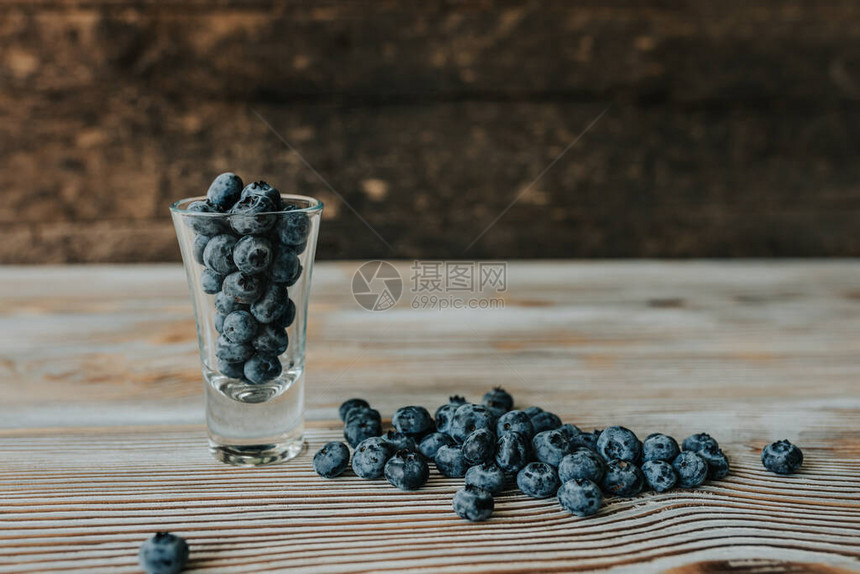 新鲜的蓝色哑光圆形蓝莓装满透明玻璃图片