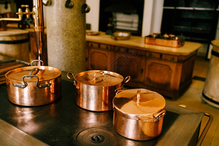 炉子上的三个铜锅图片