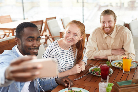 年轻朋友坐在桌边吃饭时交流沟通图片