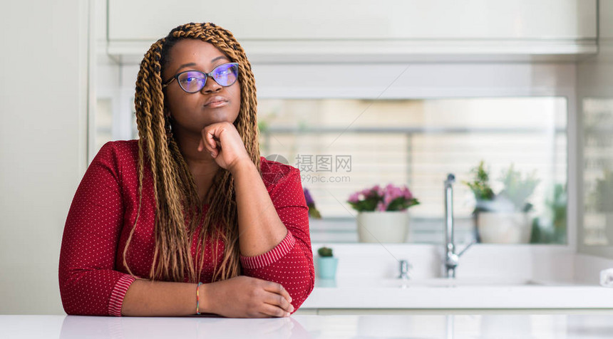 坐在家中的非裔美国妇女面对着严肃的面对地思考问题图片