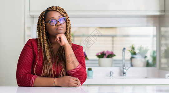 坐在家中的非裔美国妇女面对着严肃的面对地思考问题图片