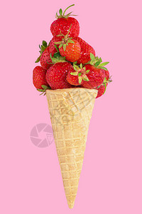 粉红色背景上装满草莓的冰淇淋甜筒华夫饼圆锥里有新鲜草莓图片