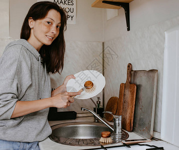 用零废物洗碗机洗盘子的女人图片