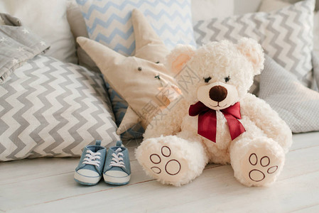柔软的玩具熊和婴儿运动鞋图片