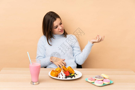 青少年女孩吃孤立的华夫饼在蜜蜂背景图片