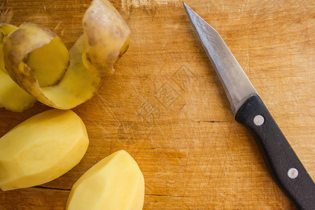 在厨房工作做饭用木板亲手清理的土豆浴缸就在刀子旁图片