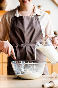 以面粉将牛奶倒入碗中的幸福妇图片