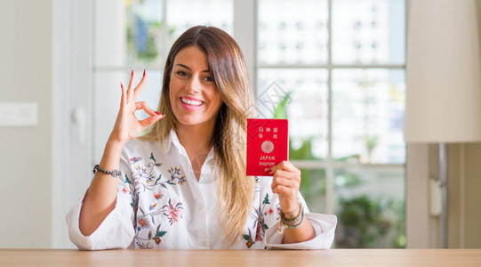 在家拿着日本护照的年轻女人用手指做ok标志图片