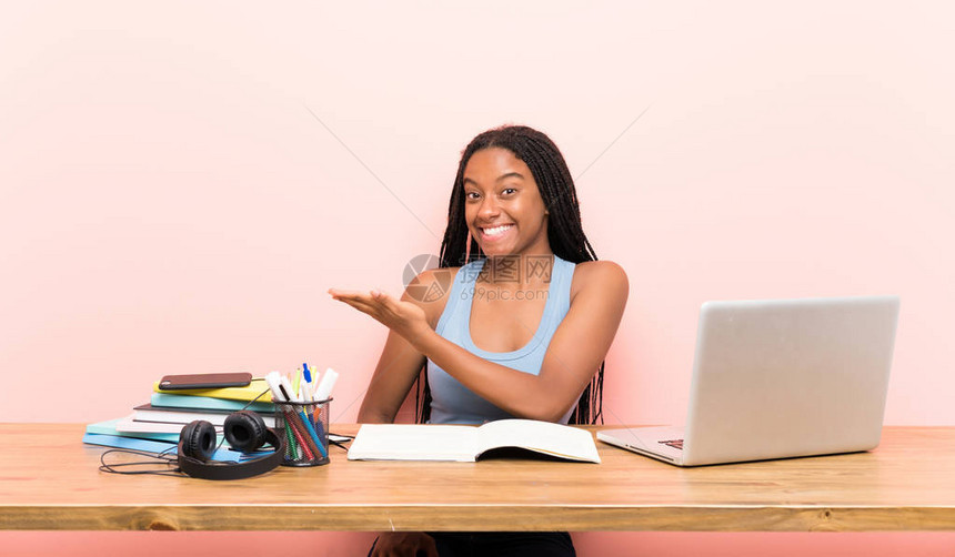 在工作场所留着长辫子的非洲裔美国少女学生一边微笑一边图片