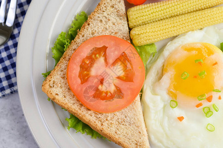 炸鸡蛋在吐司上铺着胡萝卜玉米宝和洋葱的胡椒图片