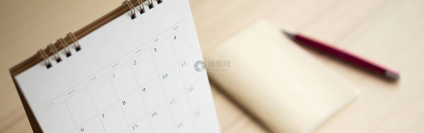 用笔和记本结束木制表背景的日历页商业规划任命会议概图片