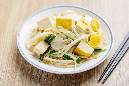 亚洲素食木桌上的豆腐和筷子以及图片