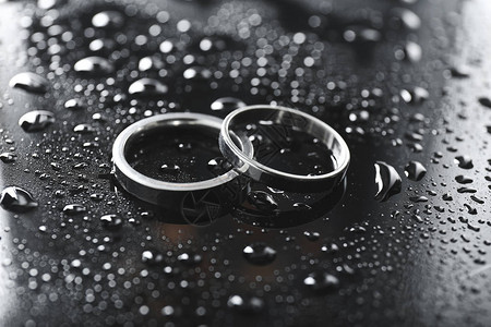 湿桌上的一对结婚戒指图片
