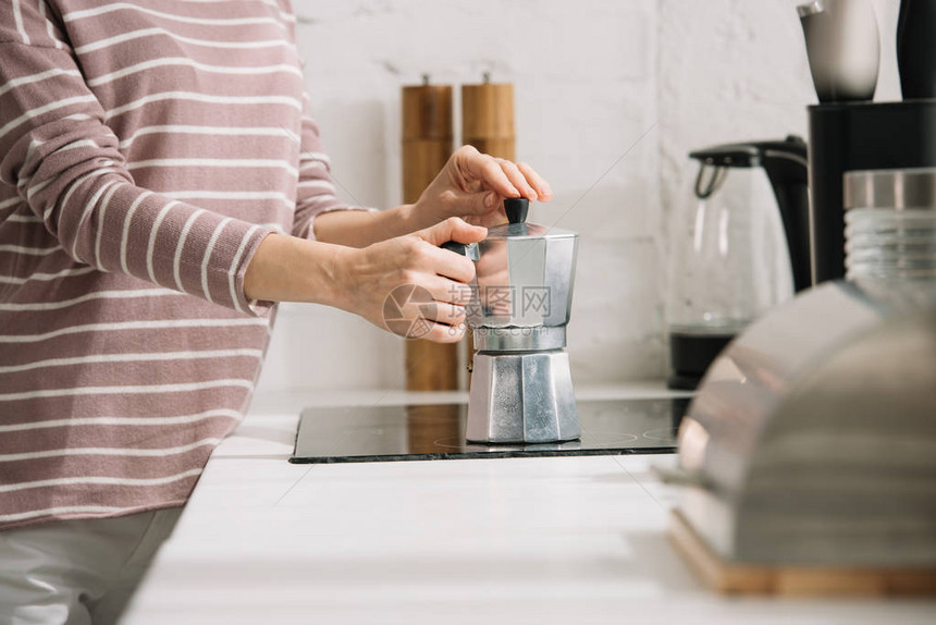 女用玻璃制咖啡机煮咖啡的妇图片