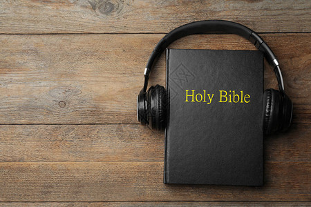 木制背景的圣经和耳机图片