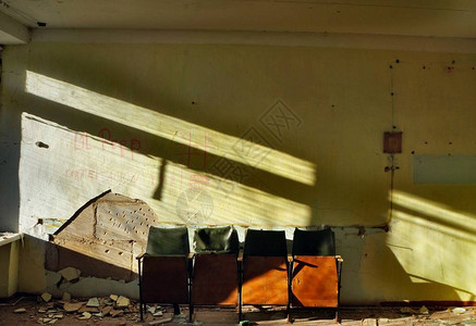 在废弃房屋的旧椅子墙上的阴影年老图片