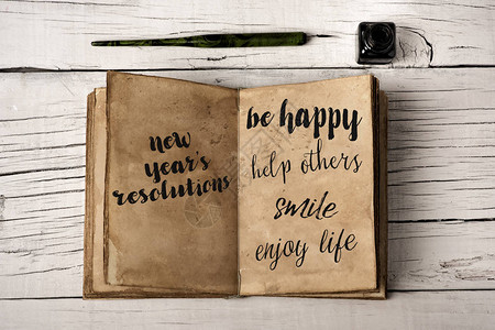 例如快乐帮助他人微笑或享受生活笔尖和一瓶在质朴的白色木桌背景图片
