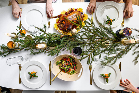 圣诞晚宴美味的传统节日餐和吃它们的人手装饰着美味菜肴的餐桌平莱伊背景图片