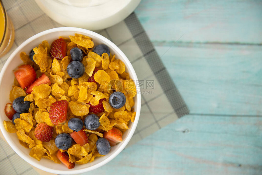 健康的早餐橙汁水果草莓蓝莓和麦片放在垫子和木桌上的碗里背景健康食品图片
