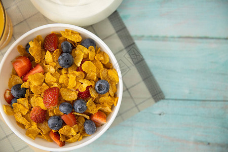 健康的早餐橙汁水果草莓蓝莓和麦片放在垫子和木桌上的碗里背景健康食品图片