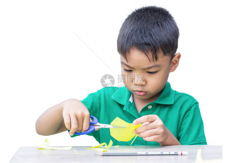 选择焦点5至6岁亚洲儿童男孩练习用木桌上的剪刀彩纸的肖像图在家学习社交距离孩图片