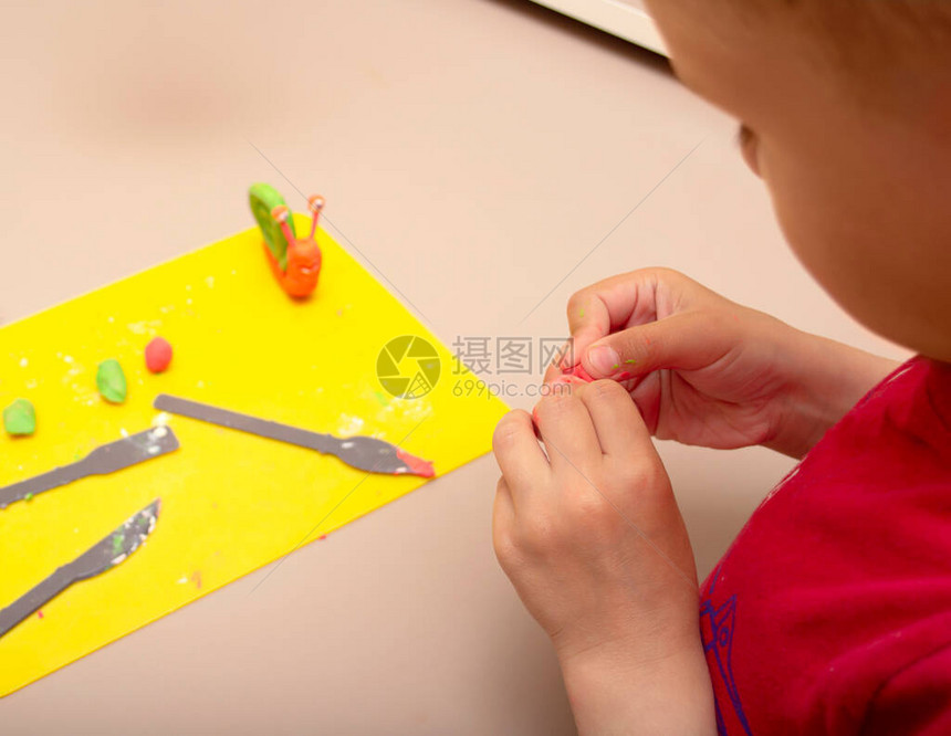 红毛衣雕塑中的孩子用塑料制成的蜗牛图片