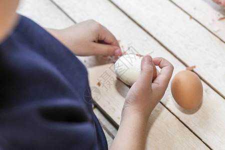 帮助母亲准备早餐的小孩6岁的孩子清理蛋壳一个小男孩正在清洗鸡图片