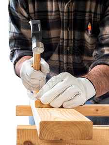 木匠用手套保护他的双手用锤子和钉子修木板建筑业图片