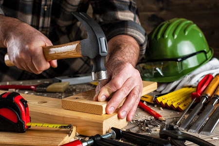 特写木匠用锤子和钉子固定木板建筑行业图片