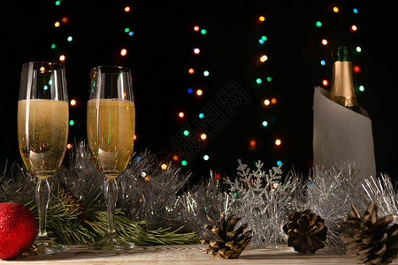 圣诞和一对情侣的浪漫晚宴与两杯香槟相爱银色罐头和桌边的树枝黑色复制空图片