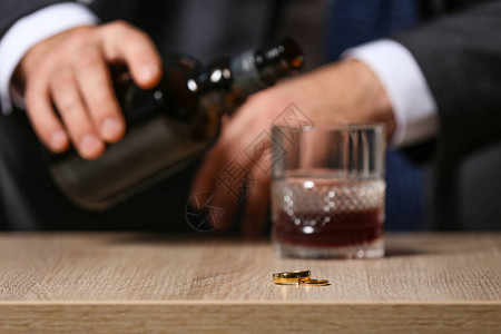 离婚男子在家喝白兰地酗酒的概念图片