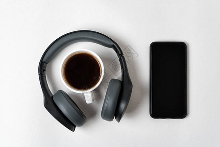 无线全尺寸耳机智能手机和白底咖啡杯图片