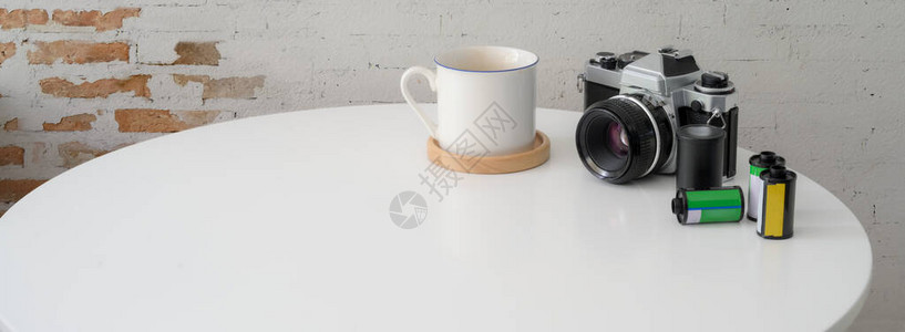 在白色圆桌上使用相机咖啡杯和复印空间近距离查看图片