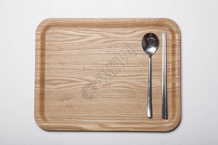 带勺子的木托盘白桌上的筷子图片