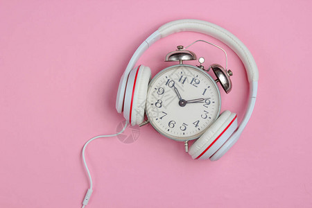 闹钟和粉红背景的经典耳机图片