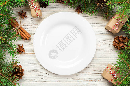 上方视图木制圣诞节背景的空板圆陶瓷假日晚餐菜式概念图片