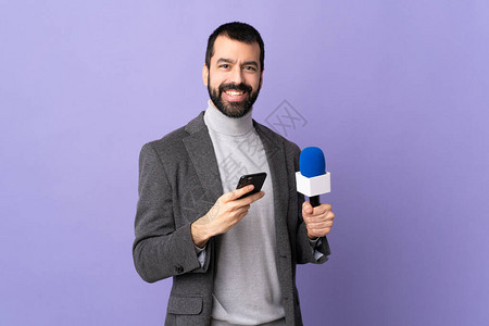 留胡子的成人记者男子拿着麦克风对着隔绝紫色背景的孤立紫色背景使用图片