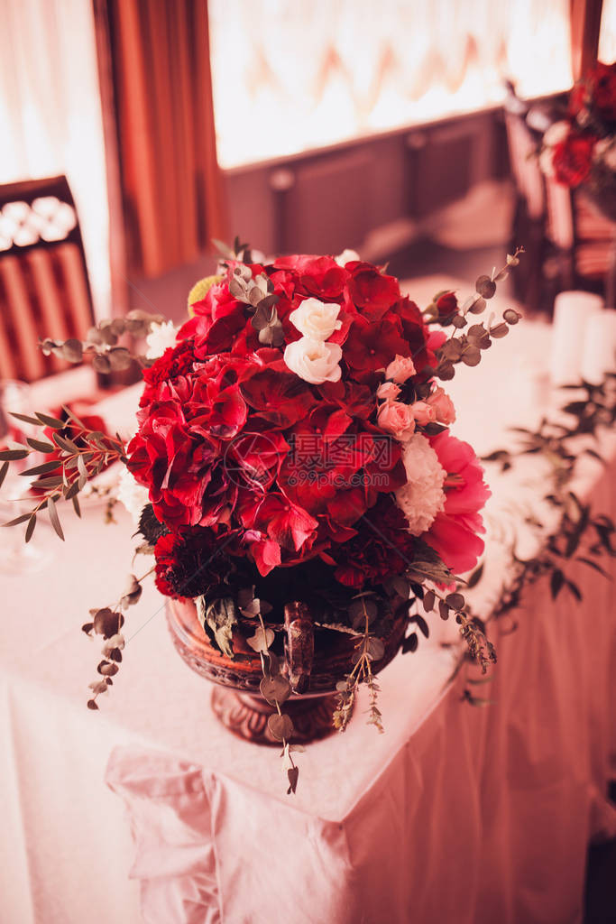 婚礼桌上有鲜花的红色花束图片
