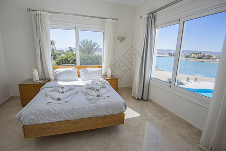 带家具和热带海景的豪华展示房双人卧室的图片