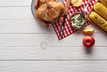 火鸡和蔬菜在白木餐桌上配有格子餐巾纸的白木桌边用图片