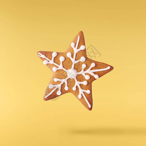 圣诞贺卡概念圣诞节姜饼明星在黄色背景下坠入空气中图片