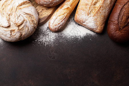 石头桌上有各种地壳面包和面包您文字的顶端图片