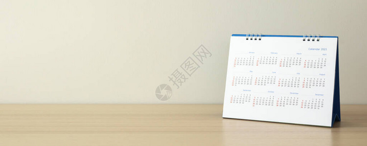 日历页特写在木桌上白墙背景业务规划背景图片
