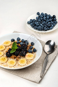 燕麦粥配香蕉核桃黑莓蓝莓蜂蜜和薄荷图片